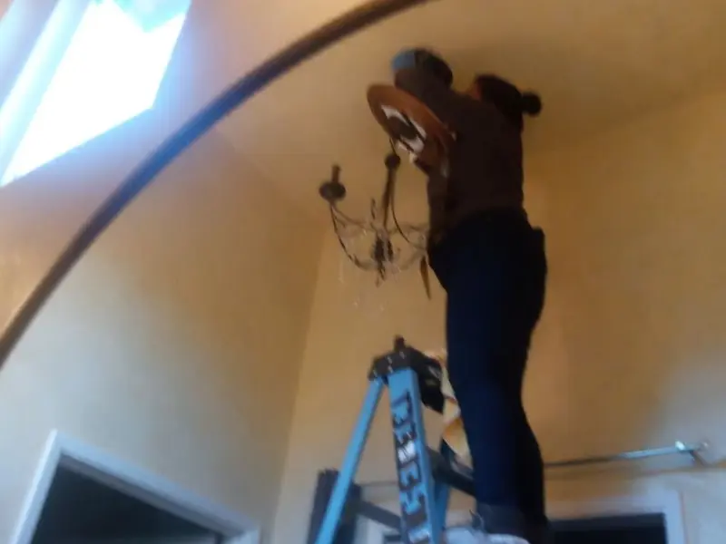 Electrician installing a chandelier in a Indian Head Park residence
